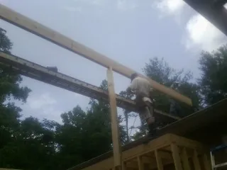 Carpenter setting a ridge beam over a new addition frame — Ice Dam Removal by Roofing Brothers in Pitman