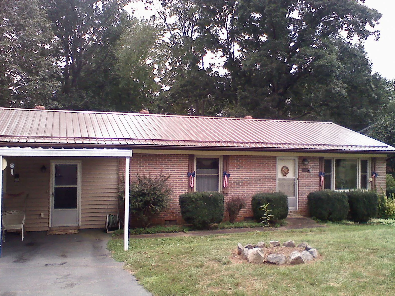 Bronze metal roof and carport on a brick ranch home — Roof Repair work by our crew in Pitman